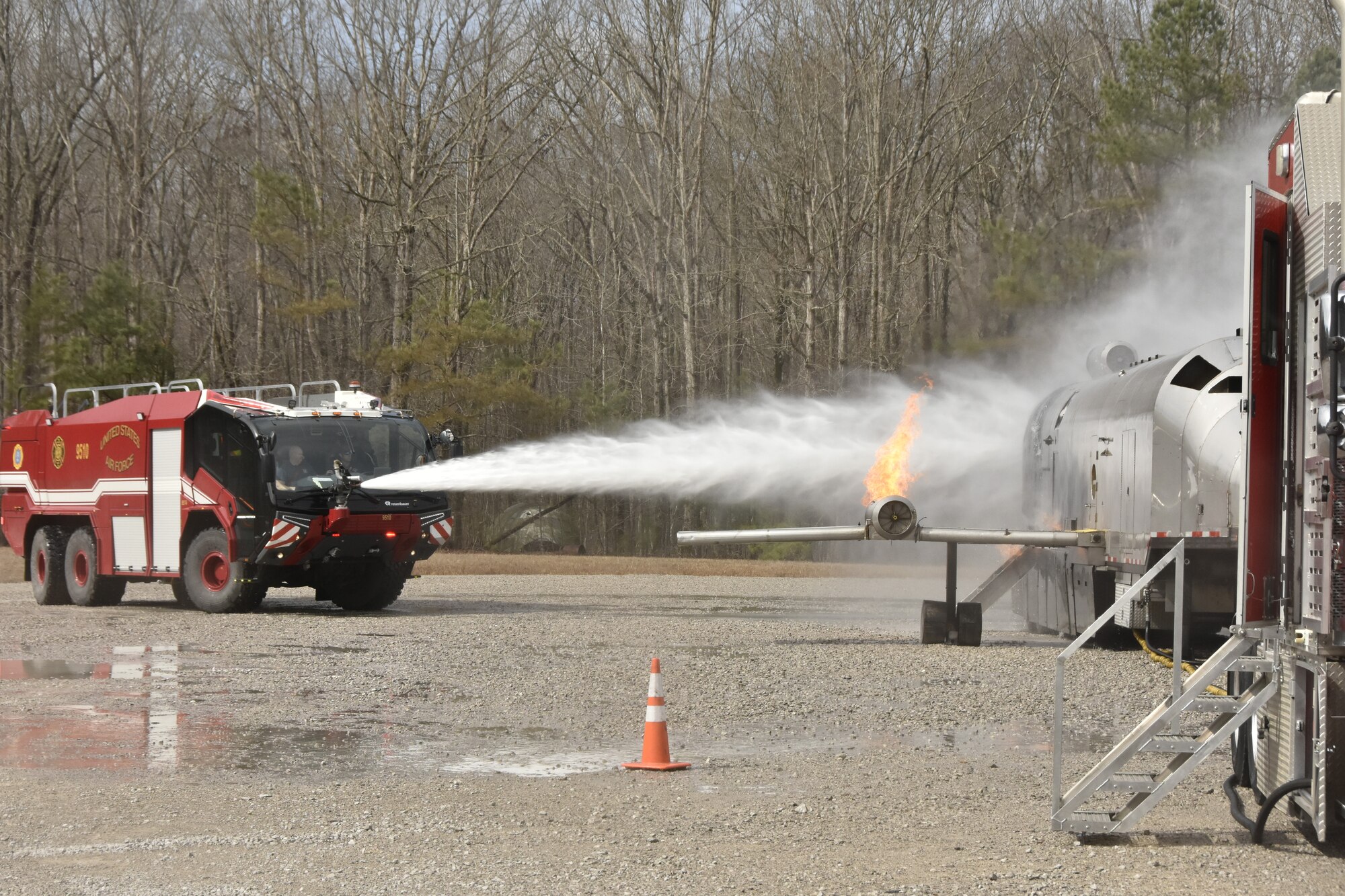 An Arnold Air Force Base Fire and Emergency Services Aircraft Rescue and Fire Fighting truck is used to spray water on an exterior aircraft fire during fuselage fire training March 7, 2024, at Arnold AFB, Tenn., headquarters of Arnold Engineering Development Complex. Arnold FES crews took part in live structural fire training Feb. 27-29, 2024, and live aircraft fire training March 5-7, 2024. (U.S. Air Force photo by Bradley Hicks)