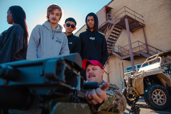 Oklahoma high school students are shown a weapon system during the 137th Special Operations Wing 2024 Student Flight Fest Invitational event held at Will Rogers Air National Guard Base, Oklahoma March 28, 2024. The invitational allowed for students, educators and other visitors from across the state to broaden their understanding of what the Oklahoma Air National Guard has to offer through aircraft displays, interactive stations, and discussions with Airmen and Soldiers from diverse career fields.