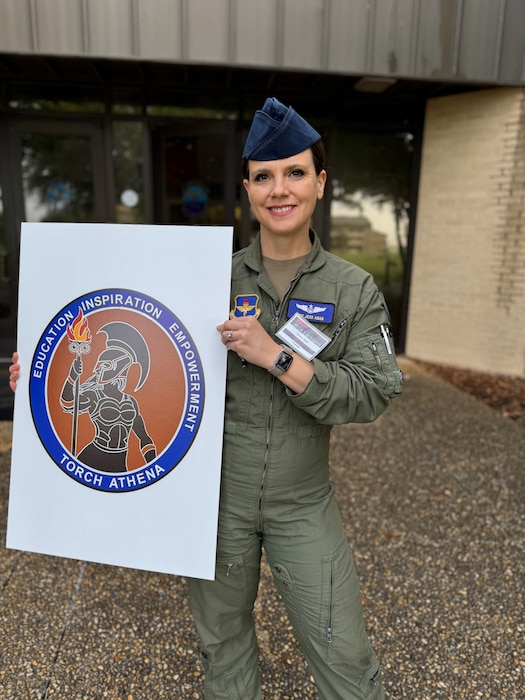 U.S. Air Force Master Sergeant Jessica Abad holds Air Education and Training Command’s new Torch Athena logo at Joint Base San Antonio-Lackland, Texas. Abad was recognized by U.S. Air Force Major General James Sears, Air Education and Training Command Deputy Commander for designing the new logo. (Courtesy Photo)