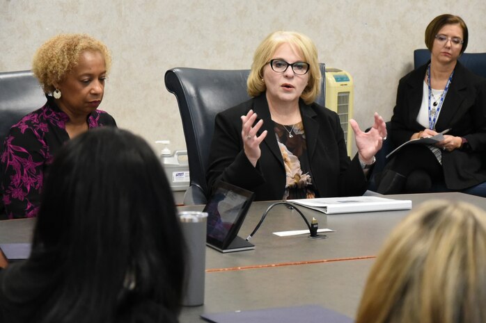 People speak around a conference table