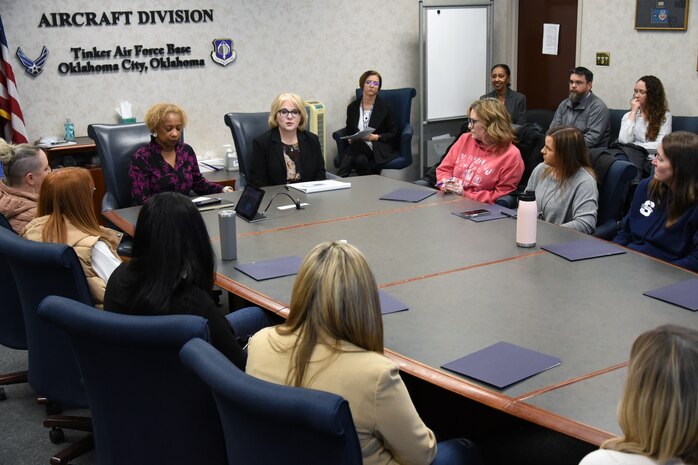 People speak around a conference table