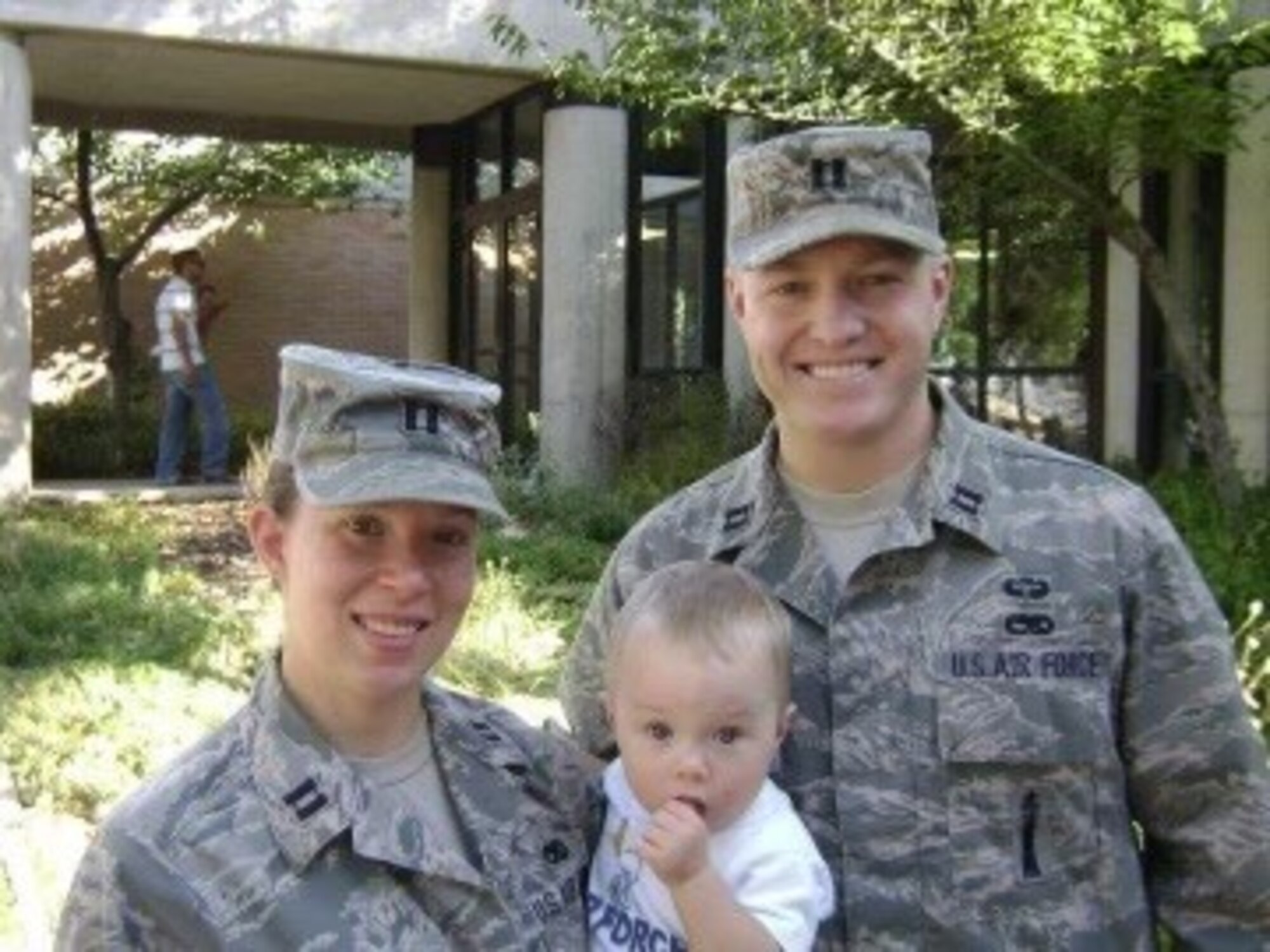 Man and woman hold a baby for photo.