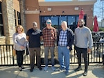 Group of five people pose for a photo.