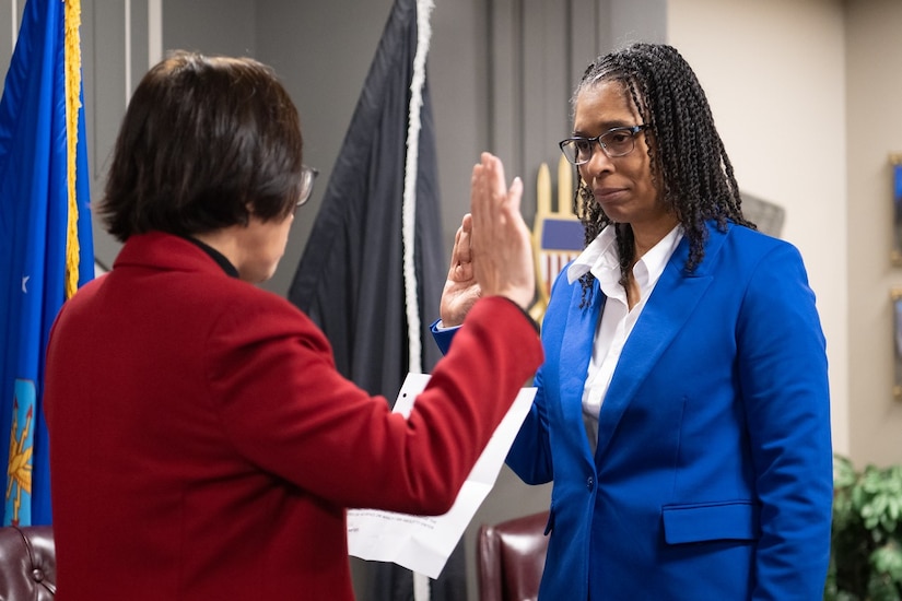 Two people face each other while raising their right hands.