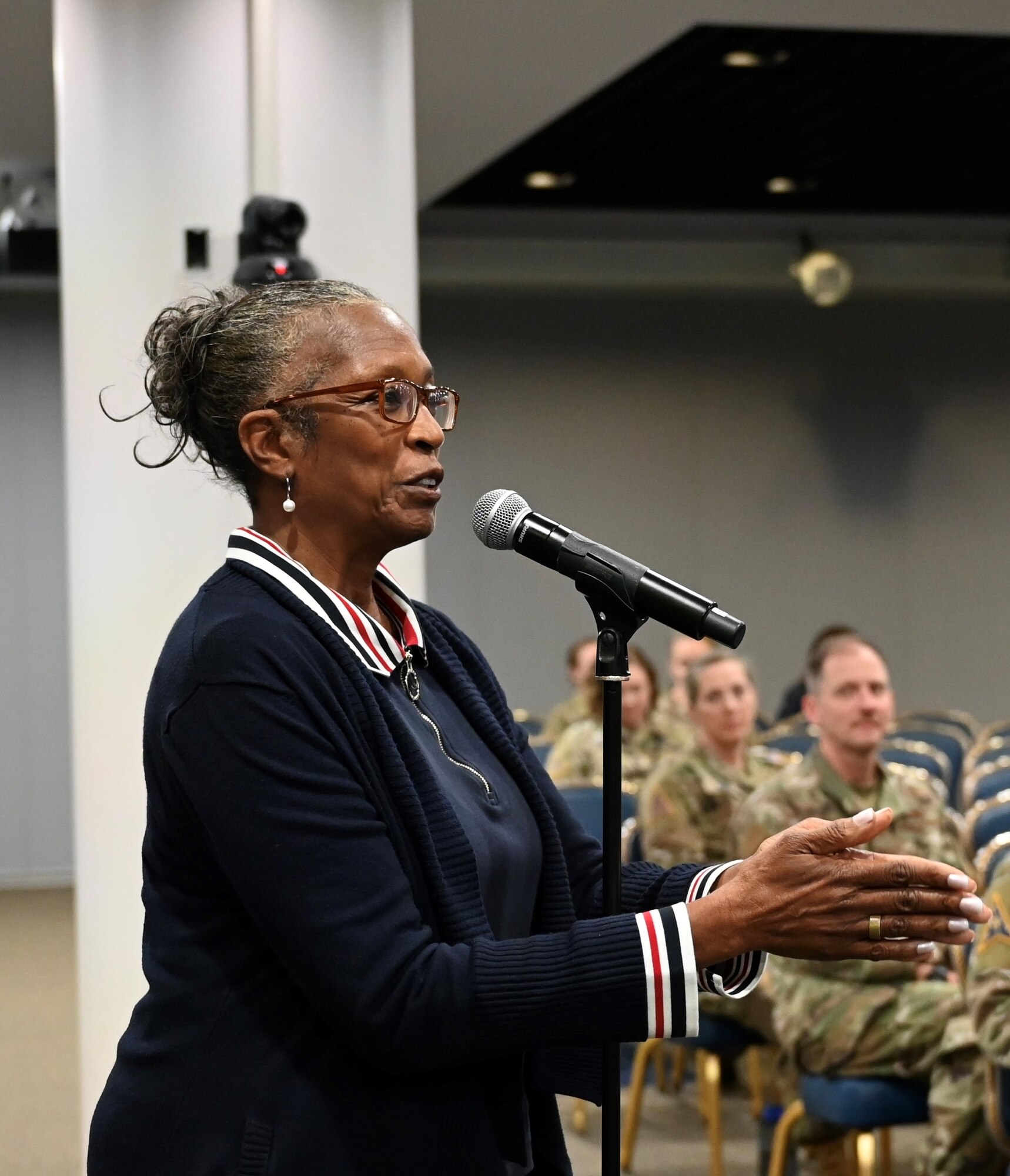 Major Brenda Threatt, Veterans Center Director, El Camino College stepped up to share her appreciation at the microphone during the Los Angeles Air Force Bases’s Women In Leadership Panel and applauded the speakers. Guardians and Airmen seated are captured in the background.