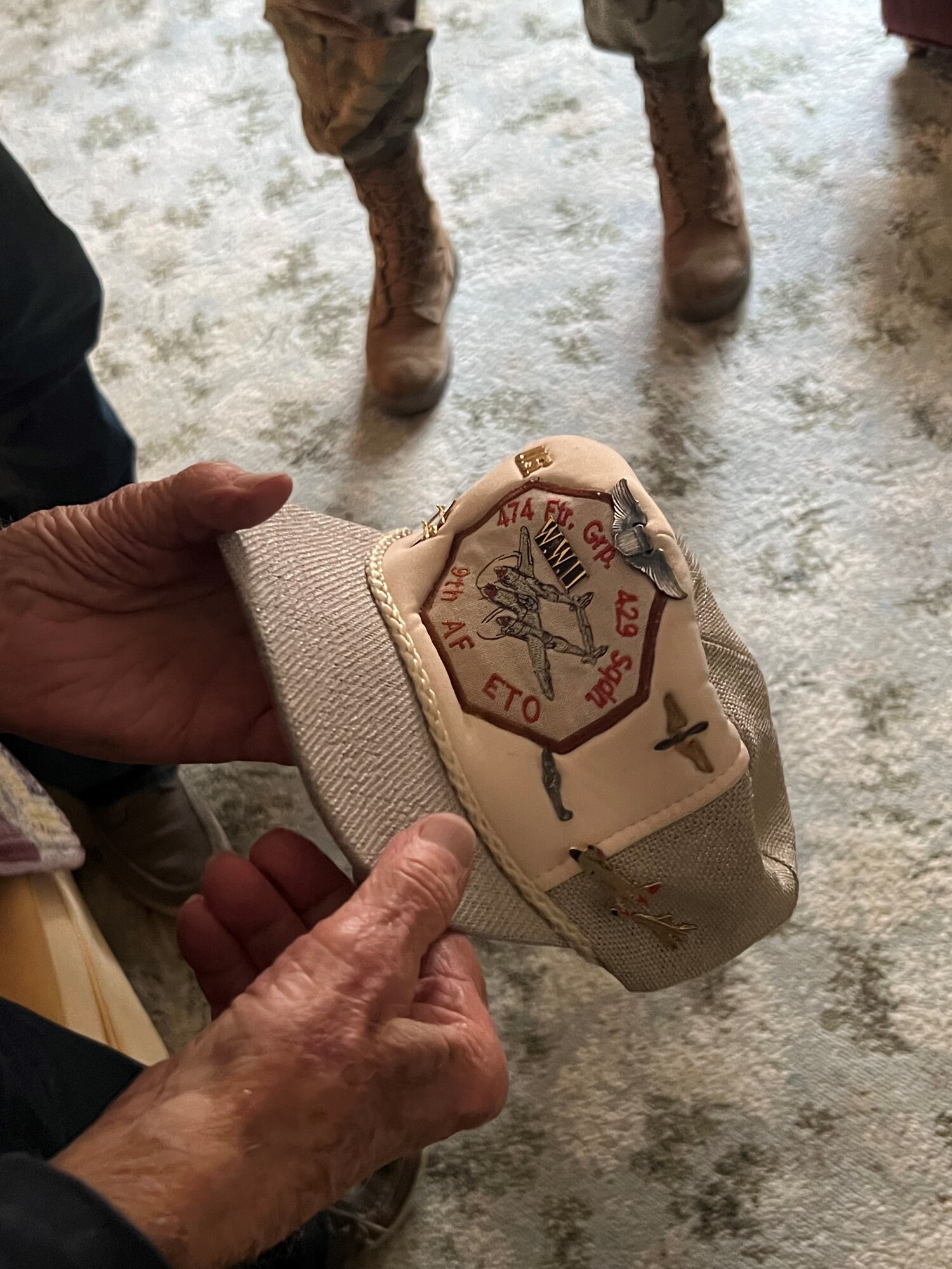 James Stark holds and shows his WWII Veteran hat. It has pins of every aircraft he has flown on it