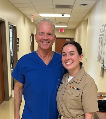 Retired Navy Capt. William Roberts, a family medicine physician at Naval Hospital Camp Pendleton, poses with Ens. Hannah Ortiz, a Uniformed Services University of the Health Sciences medical student on a family medicine rotation at NHCP. More than two decades ago, Roberts delivered Ortiz at the Camp Pendleton Naval Hospital and the two recently reconnected during the five-week rotation. Photo courtesy of Dr. William Roberts.