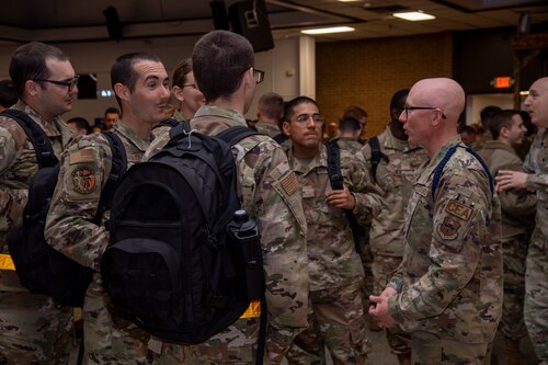 Airmen stand in a group during a function