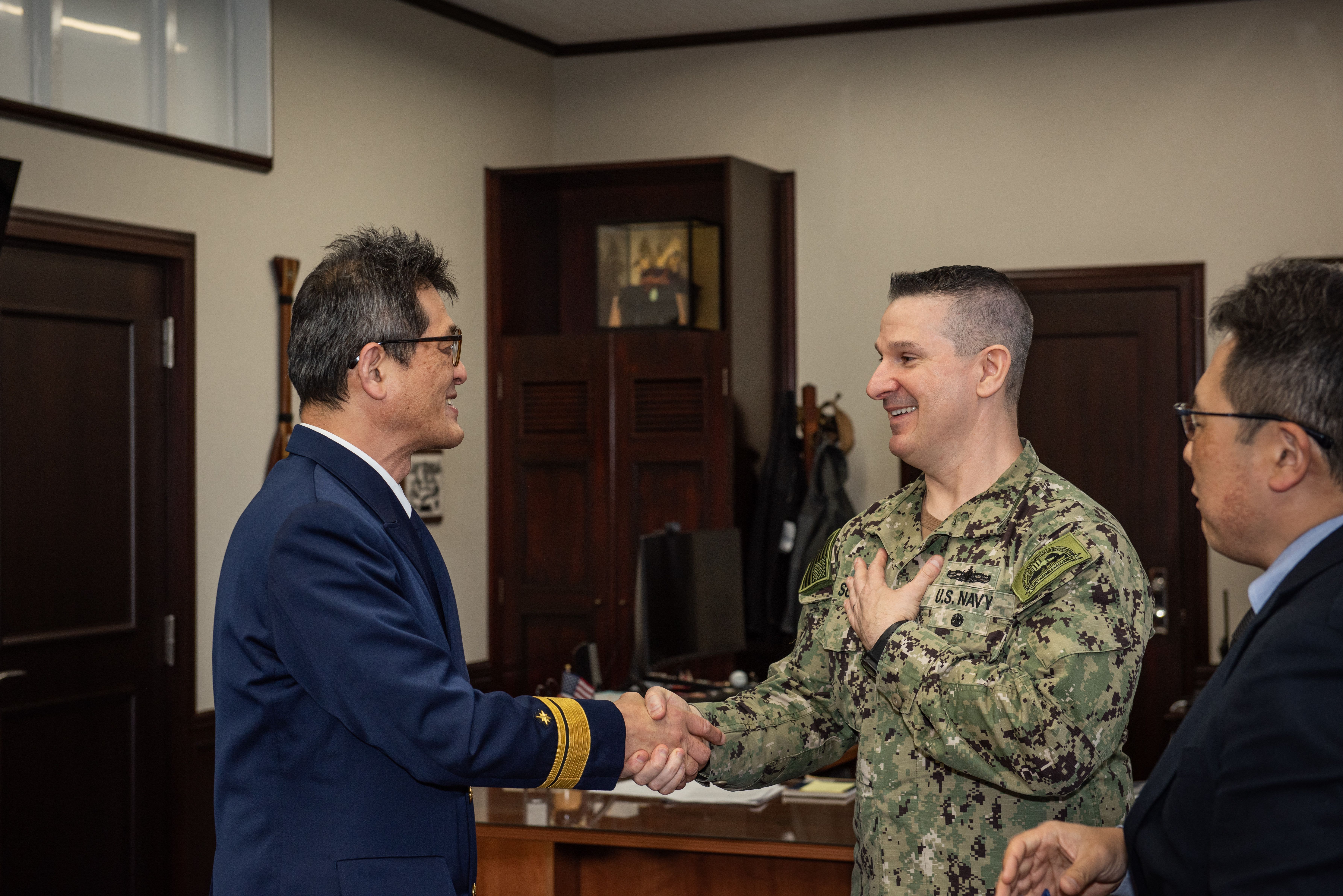 Capt. Les Sobol, Commander, Fleet Activities Yokosuka, greets Japan Coast Guard Rear Adm. Yuji Miyanagi during an office call.