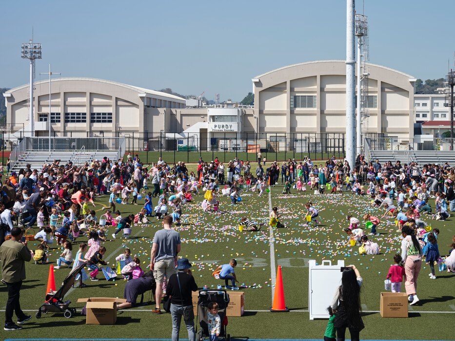 Children in the 3- and 4-year-old group race to load their baskets with candy and toy-filled eggs at Commander, Fleet Activities Yokosuka's Berkey Field March 30, 2024 during Egg'Stravaganza.