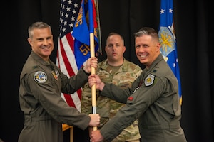 U.S. Air Force Col. Andrew J. Finkler, 850th Spectrum Warfare Group commander, left, and U.S. Air Force Lt. Col. Charles A. Friesz, 563rd Electronic Warfare Squadron commander, pass the guidon for 563rd EWS to signify Friesz’ assumption of command during the unit’s reactivation ceremony, San Antonio, Texas, April 25, 2024. The 563rd EWS remained inactive for 14 years before reactivating today as a software development organization based in 21st-century processes, practices and technologies. (U.S. Air Force photo by Jarrod M. Vickers)