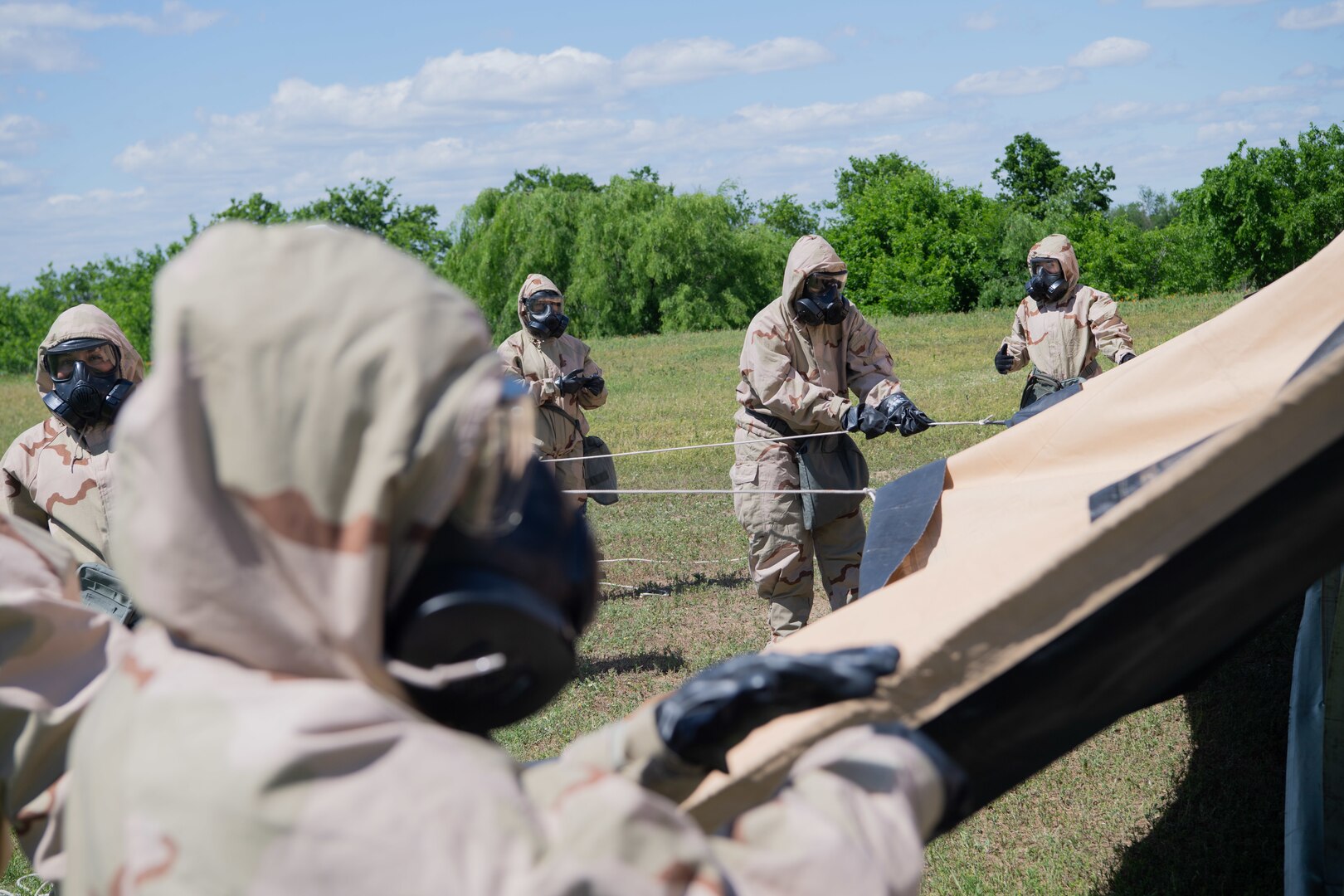 Members of the 149th Force Support Squadron pull a canopy over a shelter tent for training