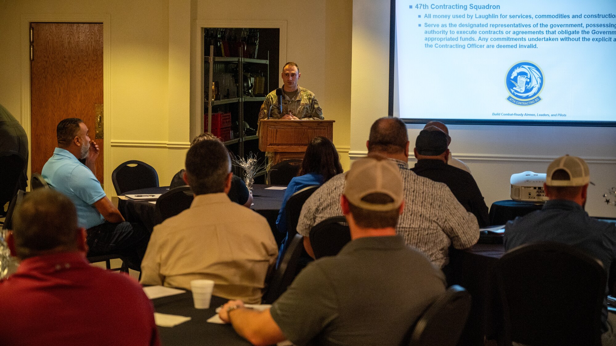 U.S. Air Force Maj. Matthew Thorne, 47th Contracting Squadron commander, briefs local business owners an overview of the 47th Contracting Squadron mission, which is overseeing all money used by Laughlin for services, commodities and construction, at Laughlin Air Force Base, Texas, April 26, 2024. By giving the information of how the government selects contracts more businesses can take part in the bidding process and have competition. (U.S. Air Force photo by Staff Sgt. Nicholas Larsen)