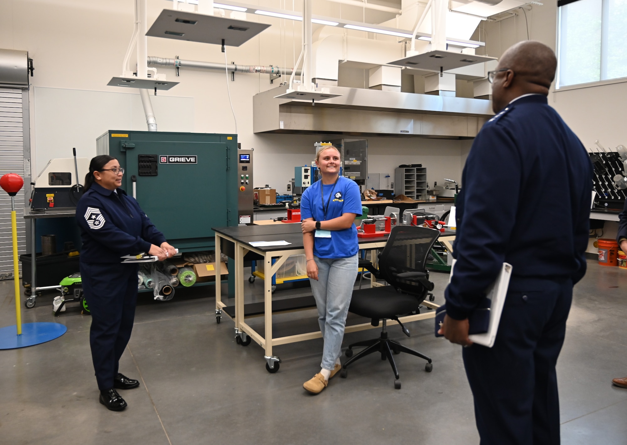Two Air Force members speak to an Angelo State University student in a lab setting