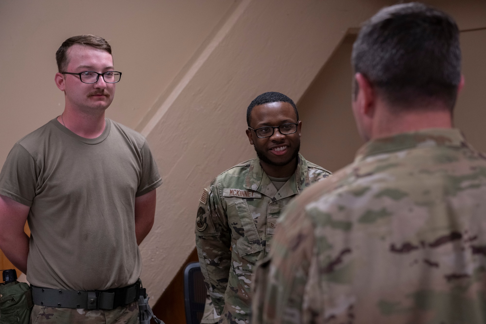 A person in the foreground talking to two people in the background of the photo.