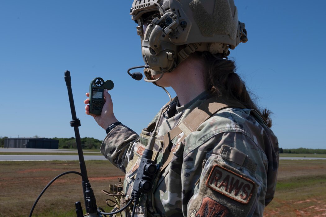 A person holding a weather device, holding it up towards the flight line.