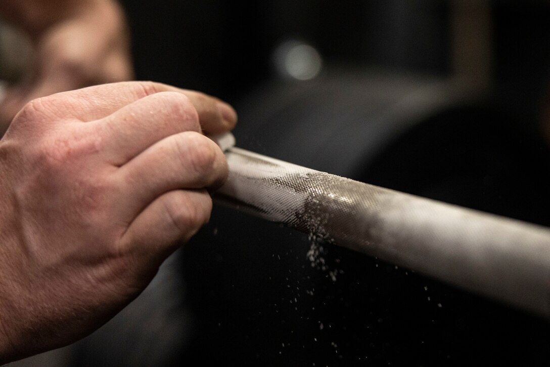 U.S. Navy Chief Quartermaster Edward Roth, assigned to USS New Orleans (LPD 18), applies chalk to the bar during a weightlifting meet aboard LPD 18 in the Sea of Japan, Sept. 4, 2022. The “1,000 Pound Club” is a weightlifting event where participants must lift a cumulative one thousand pounds in squat, bench, and deadlift. The 31st MEU is operating aboard ships of the Tripoli Amphibious Ready Group in the 7th fleet area of operations to enhance interoperability with allies and partners and serve as a ready response force to defend peace and stability in the Indo-Pacific Region. (U.S. Marine Corps photo by Sgt. Danny Gonzalez)