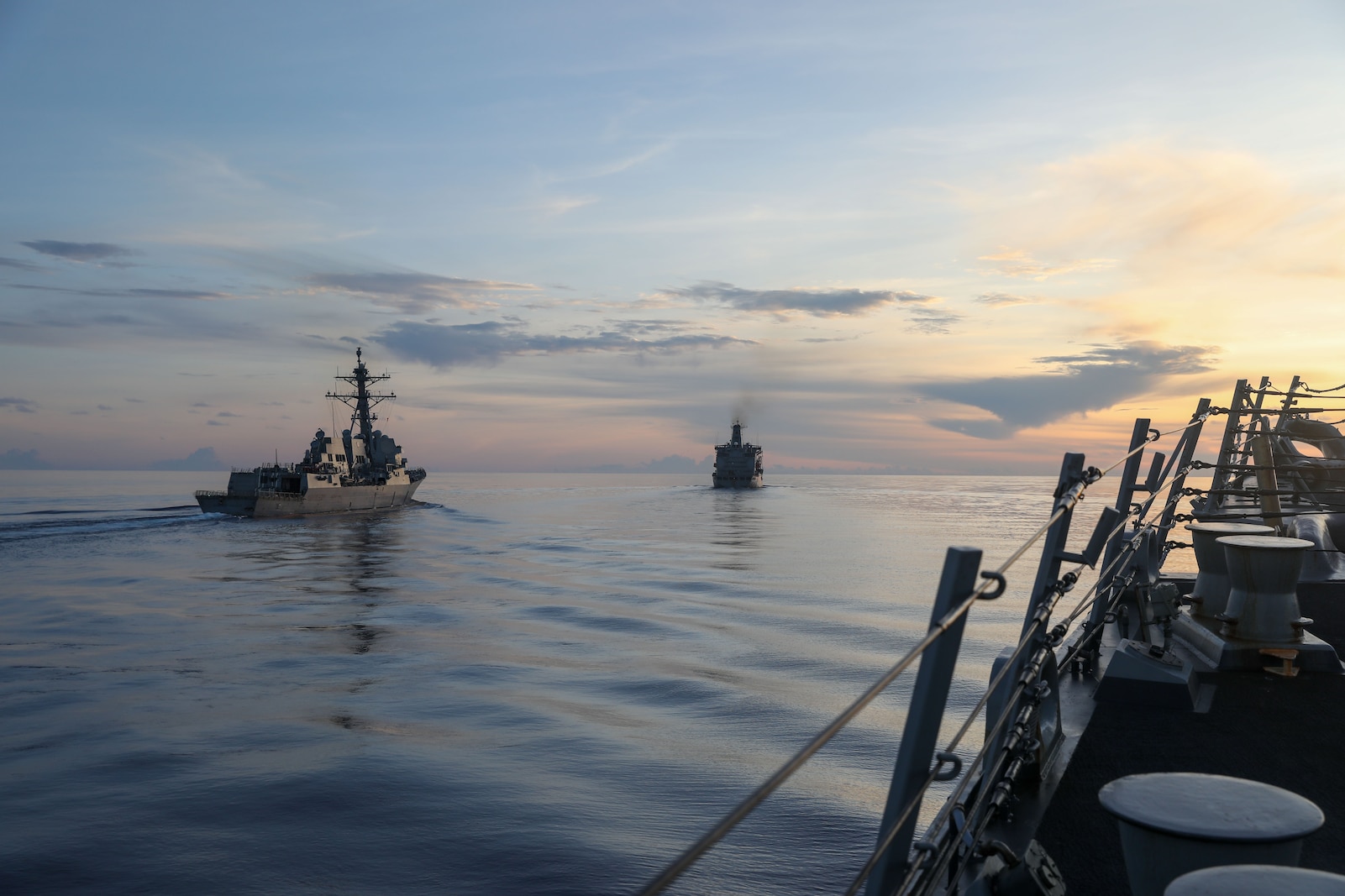 The Arleigh Burke-class guided-missile destroyer USS Howard (DDG 83) and the Arleigh Burke-class guided-missile destroyer Daniel Inouye (DDG 118) prepare to conduct a replenishment-at-sea with the Henry J. Kaiser-Class Underway Replenishment Oiler USNS John Ericsson (T-AO 194) in the South China Sea
