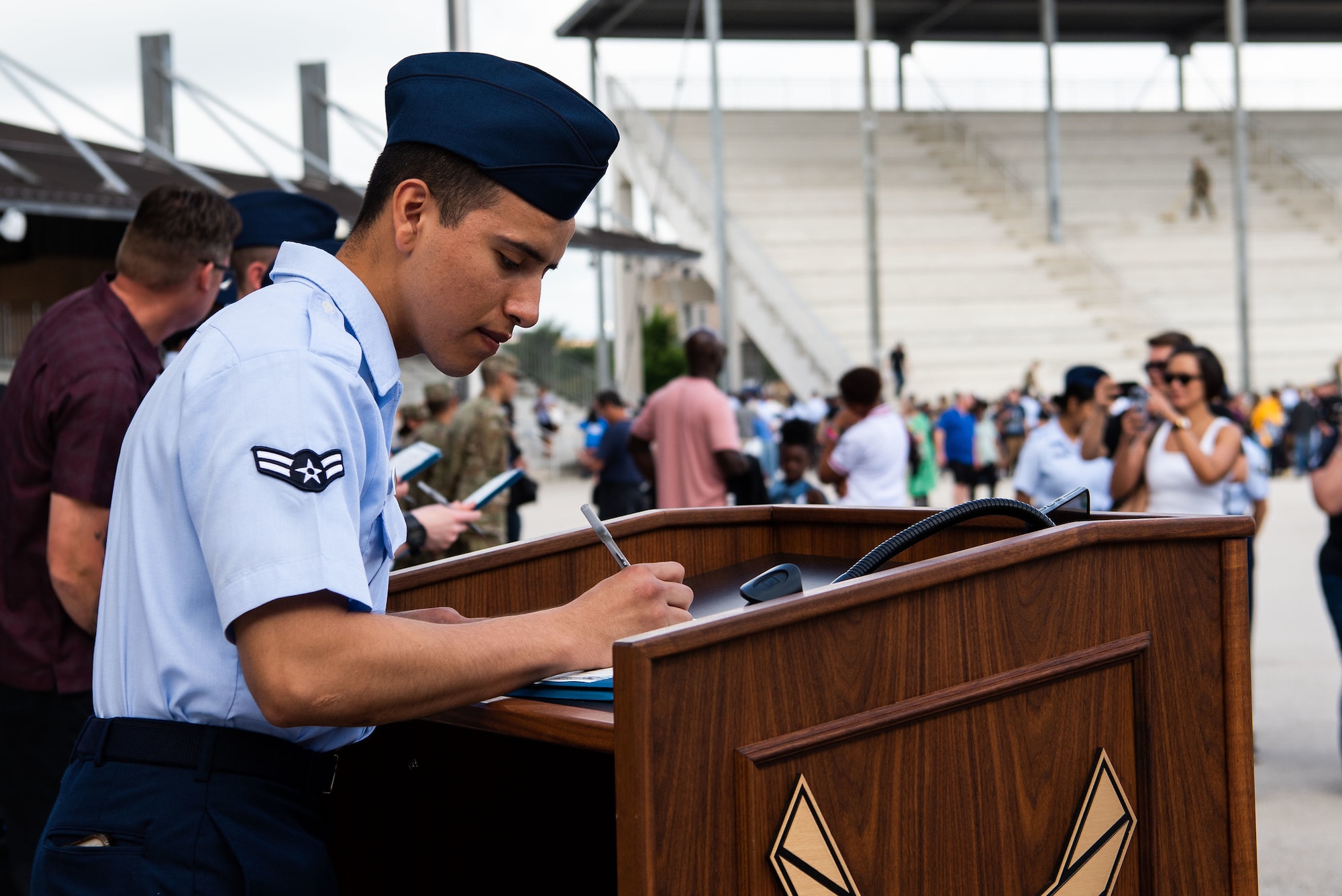 An Airman signs his U.S. Certificate of Citizenship after Basic Military Training Coin and Retreat Ceremony April 26, 2023 at Joint Base San Antonio-Lackland, Texas. The Airman was one of 14 who became U.S. citizens through the Naturalization at BMT Program.. The program, which was streamlined last year, is now online. As of May 1, 2024, more than 1,000 trainees have become U.S. citizens through the program. (U.S. Air Force photo by Vanessa R. Adame)