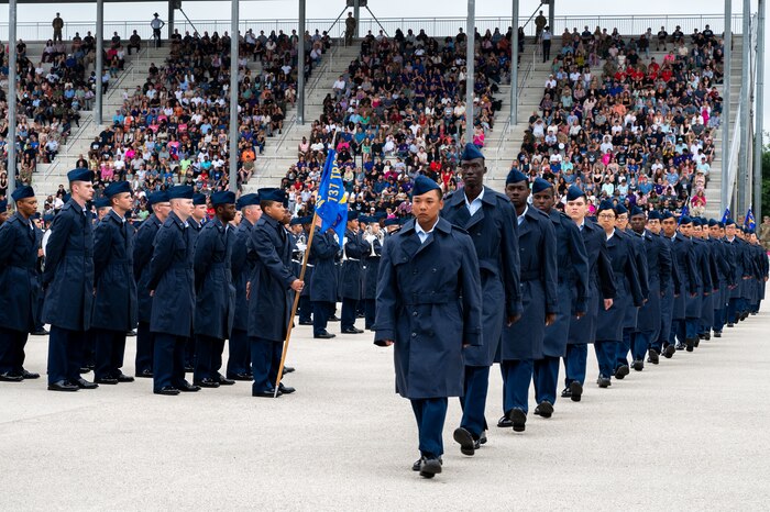 Newly naturalized U.S. citizens walk at the Pfingston Reception Center during Basic Military Training’s Coin and Retreat Ceremony, May 1, 2024, at Joint Base San Antonio-Lackland, Texas. Twenty-four Airmen were officially recognized as U.S. citizens during the ceremony. As of May 1, more than 1,000 trainees have become U.S. citizens through the Naturalization at BMT Program, which is a partnership between the 37th Training Wing and U.S. Citizenship and Immigration Services. (U.S. Air Force photo by Vanessa R. Adame)