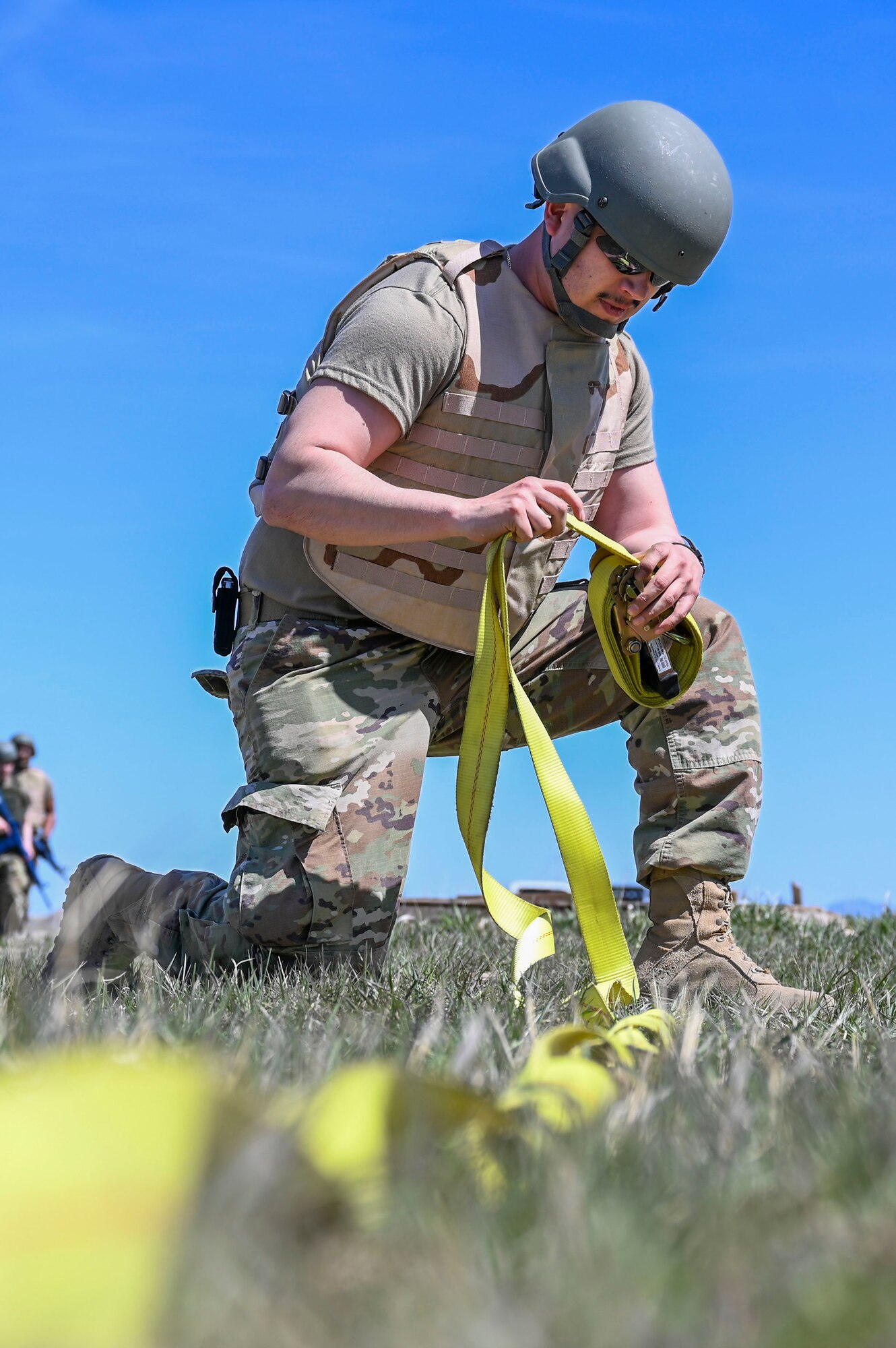 Airman rolling up a tie down strap