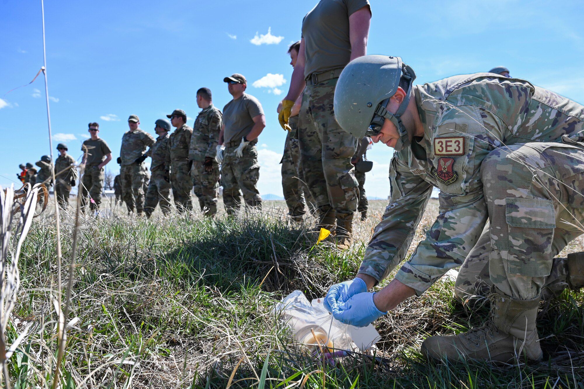 line of airmen with one kneeling to the ground