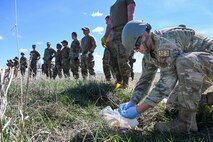 line of airmen with one kneeling to the ground