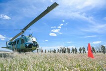 A helicopter and a line of Airmen in a field