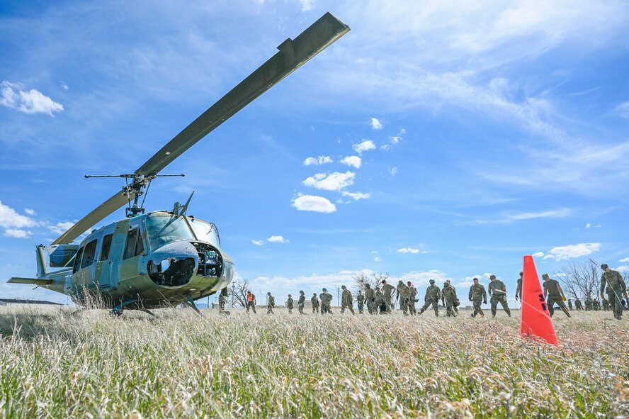 A helicopter and a line of Airmen in a field