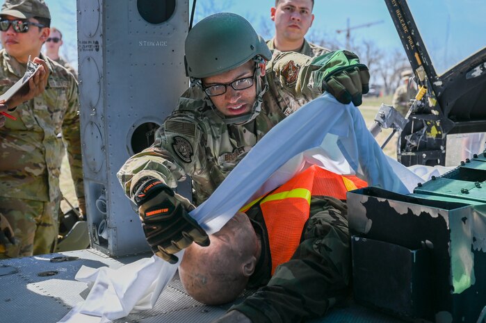 Airman lays a sheet over a mannequin