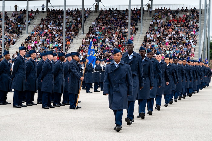 Newly naturalized U.S. citizens walk at the Pfingston Reception Center during Basic Military Training’s Coin and Retreat Ceremony, May 1, 2024, at Joint Base San Antonio-Lackland, Texas. Twenty-four Airmen were officially recognized as U.S. citizens during the ceremony. As of May 1, more than 1,000 trainees have become U.S. citizens through the Naturalization at BMT Program, which is a partnership between the 37th Training Wing and U.S. Citizenship and Immigration Services. (U.S. Air Force photo by Vanessa R. Adame)