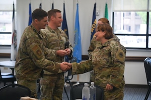 U.S. Air Force Capt. Christian Weaver, 313th Training Squadron Director of Contingency Intelligence Network Course, shakes hands with Col. Angelina Maguinness, 17th Training Wing Commander at the Cressman Dining Facility, Goodfellow Air Force Base, Texas, April 24, 2024. The 313th Training Squadron is assigned to the 17th Training Group and trains over 200 students daily in 18 advanced courses. (U.S. Air Force photo by Airman James Salellas)