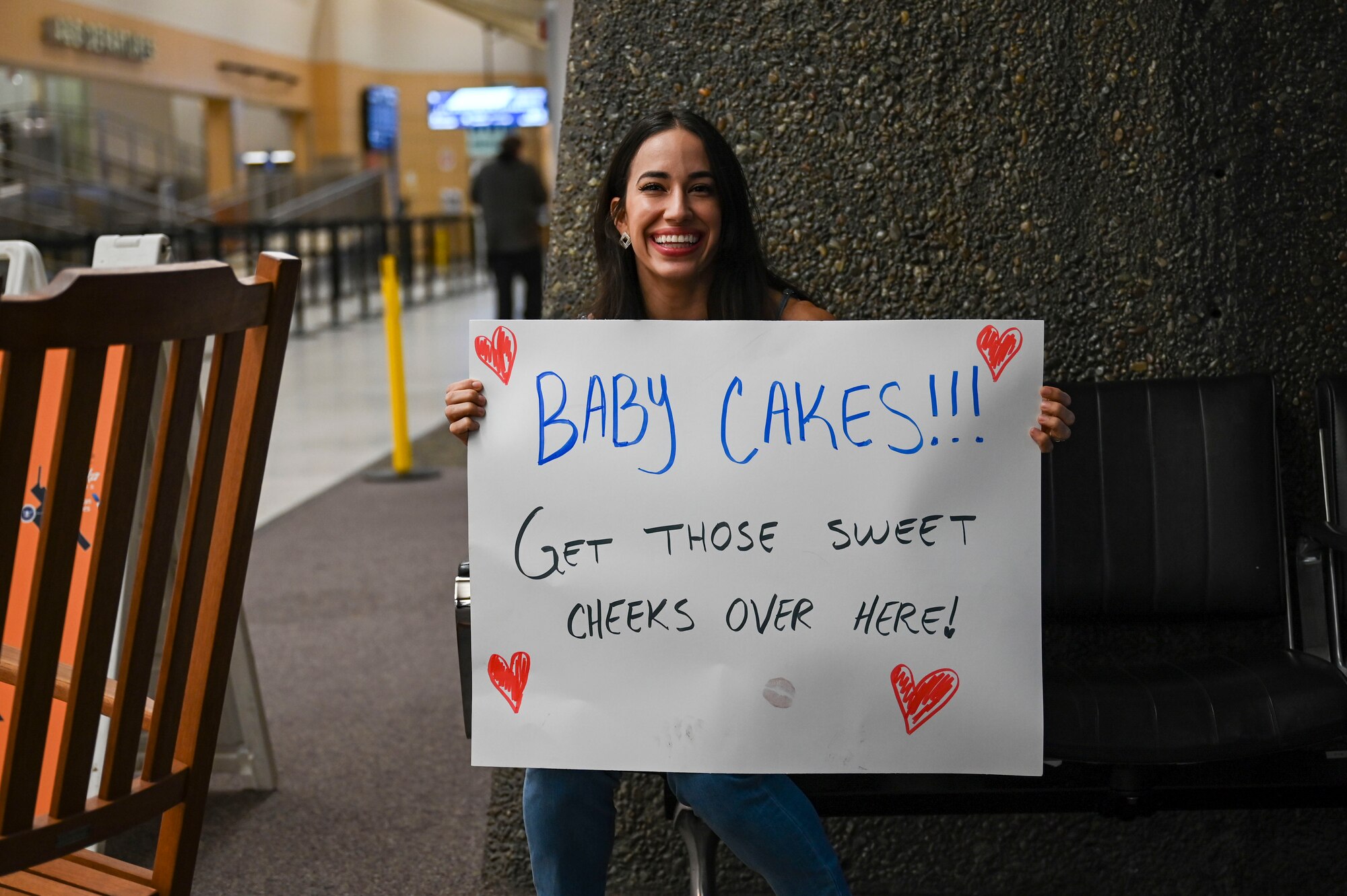 A military spouse holds a welcome home sign.