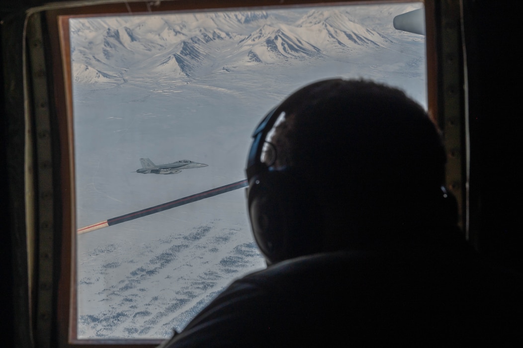 A Marine assigned to the Marine Aerial Refueler Transport Squadron (VMGR) 234 watches as an EA-18G Growler assigned to the Electronic Attack Squadron (VAQ) 131 flies by during Red Flag-Alaska 24-1 in the Joint Pacific Alaska Range Complex, Alaska, April 25, 2024.