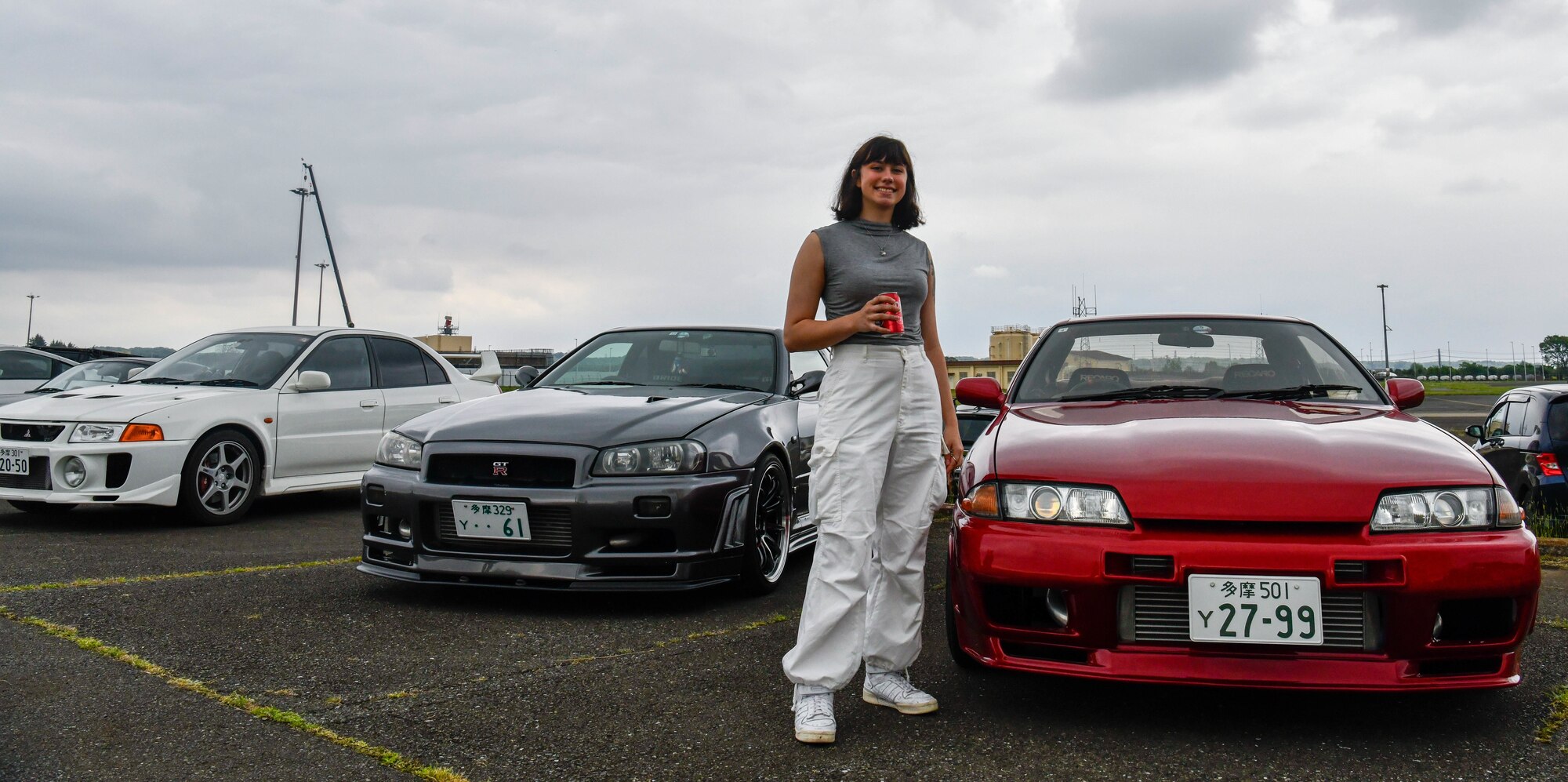 U.S. Air Force Airman 1st Class Gwyneth Lee, 374th Operations Support Squadron aircrew flight equipment technician, poses with her car.