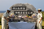 Japanese coast guardsmen decorate the Ie Shima Lighthouse Memorial Monument for Martyrs in preparation for the annual Ie Shima Lighthouse Memorial Service on Ie Shima, Okinawa, Japan, April 21, 2024. The memorial service was held to commemorate the casualties of World War II, the Ie Shima lighthouse keeper, and his family.  (U.S. Marine Corps photo by Lance Cpl. Brody Robertson)