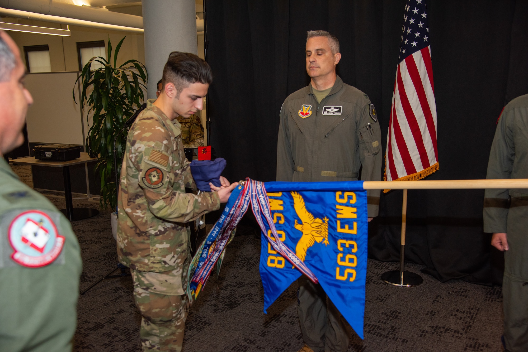 Airman 1st Class Ian Allison, 563rd Electronic Warfare Squadron software developer, unfurls the guidon for 563rd EWS during the squadron’s reactivation ceremony, San Antonio, Texas, April 25, 2024. The 563rd EWS focuses on executing software development and exploring new initiatives by embracing 21st-century processes, practices and technologies. (U.S. Air Force photo by Jarrod M. Vickers)