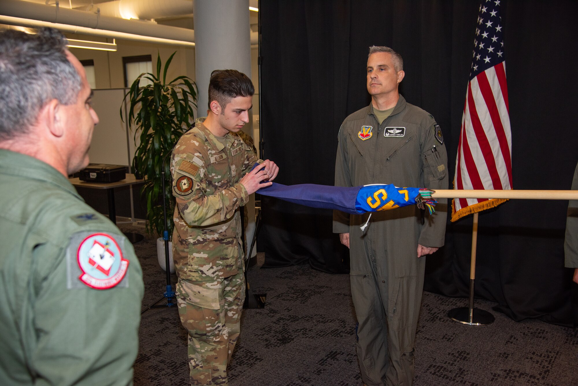 Airman 1st Class Ian Allison, 563rd Electronic Warfare Squadron software developer, unfurls the guidon for 563rd EWS during the squadron reactivation ceremony, San Antonio, Texas, April 25, 2024. The reactivation reestablishes the unit’s new mission of creating the next generation of impact on electromagnetic warfare through software development. (U.S. Air Force photo by Jarrod M. Vickers)