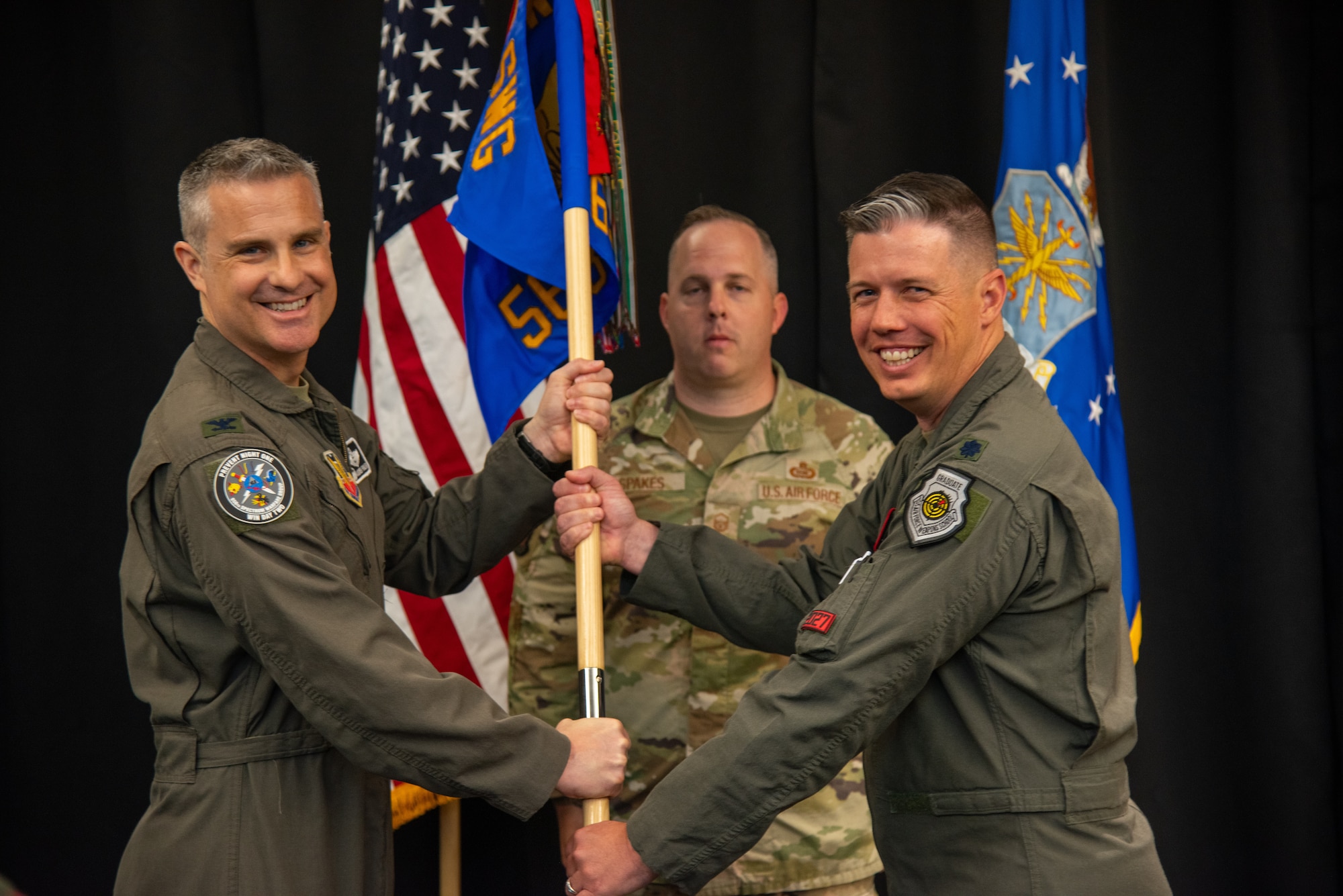 U.S. Air Force Col. Andrew J. Finkler, 850th Spectrum Warfare Group commander, left, and U.S. Air Force Lt. Col. Charles A. Friesz, 563rd Electronic Warfare Squadron commander, pass the guidon for 563rd EWS to signify Friesz’ assumption of command during the unit’s reactivation ceremony, San Antonio, Texas, April 25, 2024. The 563rd EWS remained inactive for 14 years before reactivating today as a software development organization based in 21st-century processes, practices and technologies. (U.S. Air Force photo by Jarrod M. Vickers)