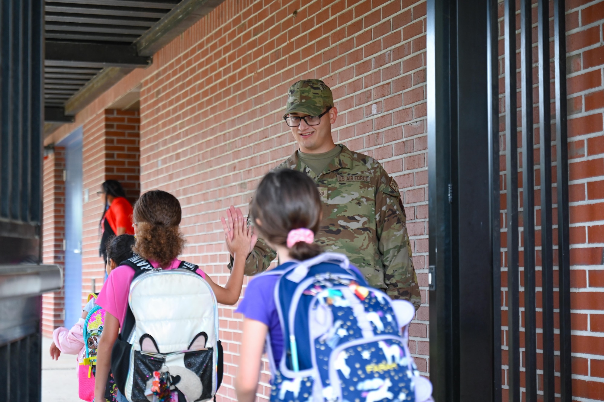 U.S. Air Force Staff Sgt. Adam Pickard, 87th Electronic Warfare Squadron, COMBAT SHIELD avionics electronic warfare journeyman, high fives school children on their way into school at Shalimar Elementary, Shalimar, Florida, April 29, 2024. The principal of Shalimar Elementary serves as the 87th EWS’ honorary commander, and invited Airmen to participate in the school’s Military Monday. (U.S. Air Force photo by Capt. Benjamin Aronson)