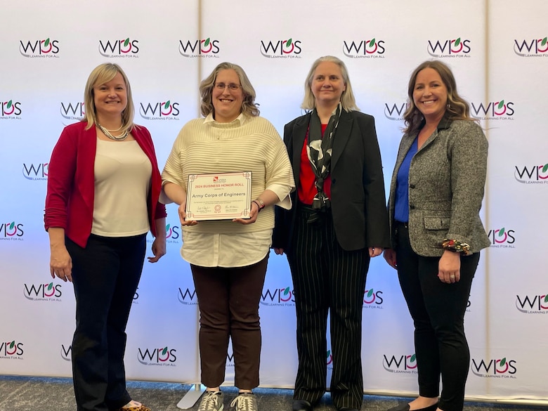 Four women receiving award.