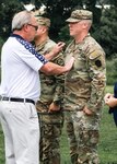 Joseph Ellis (right), who was promoted from sergeant to staff sergeant, gets his new rank pinned on by his father during a ceremony at Fort Indiantown Gap on July 9, 2023. (Sgt. Ashley Standard)