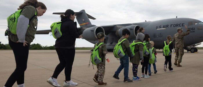 kids line up in front of airplane