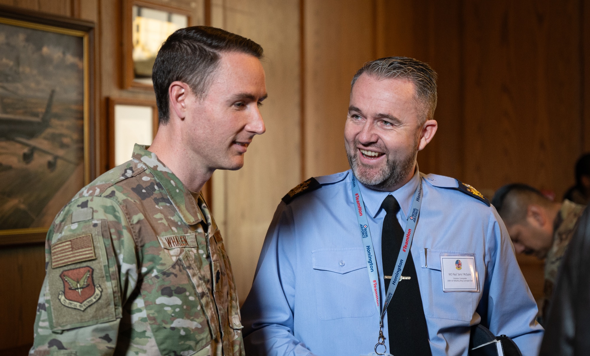 U.S. Air Force Lt. Col. Zachary Whalen, left, 352d Special Operations Wing director of staff, speaks with Royal Air Force Warrant Officer Paul McGuire, RAF Honington station warrant officer, during a refreshment break in the honorary commanders’ induction ceremony at RAF Mildenhall, England, April 24, 2024.