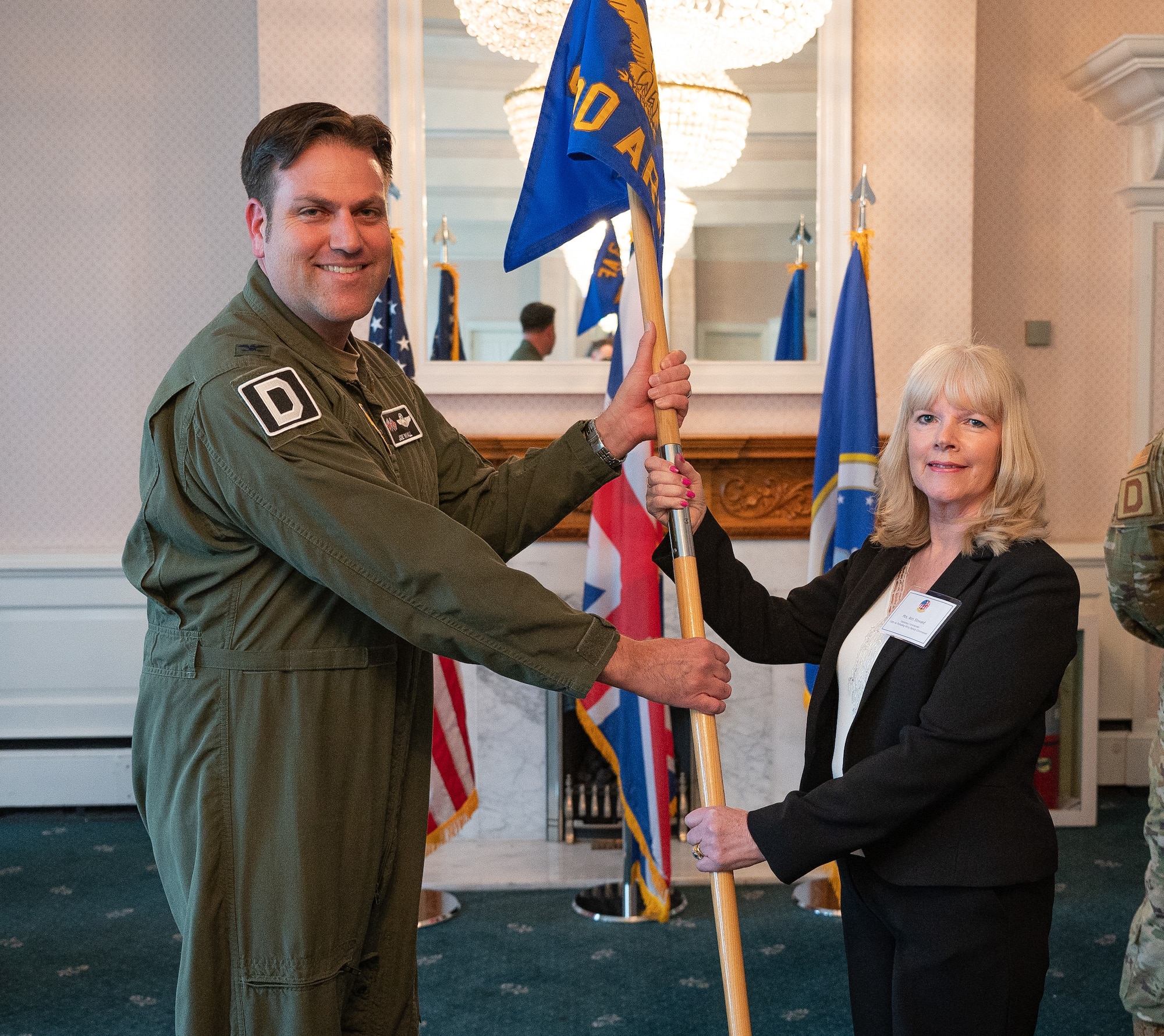 U.S. Air Force Col. Joseph Wall, left, 100th Air Refueling Wing deputy commander, passes the 100th ARW guidon to Ann Steward, Visit East Anglia project manager, during the Honorary Commanders’ induction ceremony at RAF Mildenhall, England, April 24, 2024.
