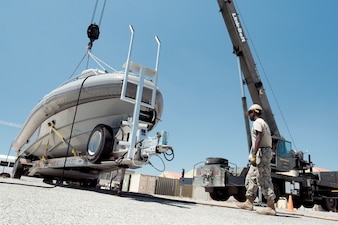 EO3 Charles Mathenge, from NMCB-11, moves a boat at Naval Station Rota, Spain.