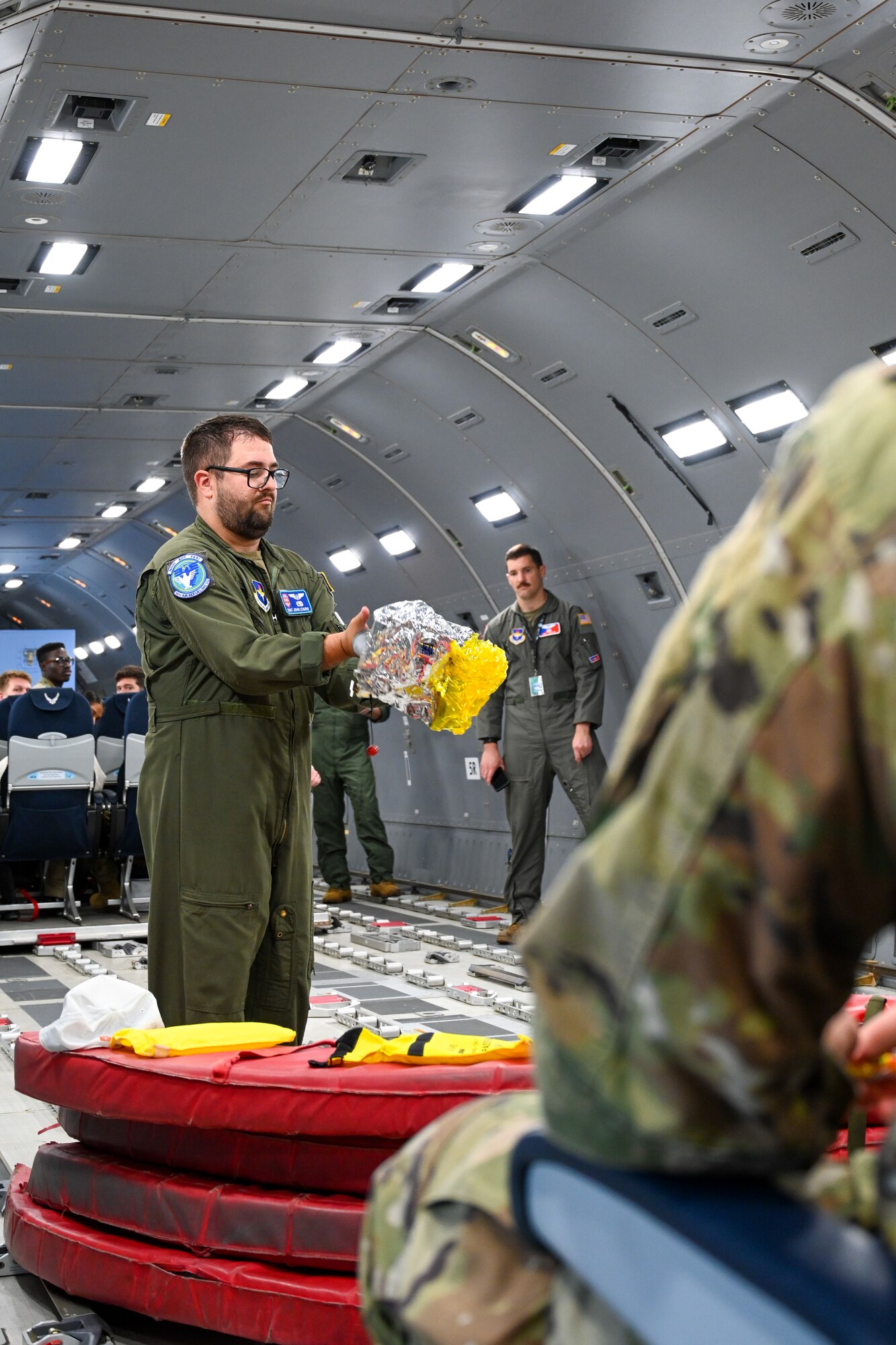U.S. Air Force Staff Sgt. John Levario, 56th Air Refueling Squadron boom operator instructor, demonstrates the use of emergency equipment at Altus Air Force Base, Oklahoma, April 25, 2024. This demonstration is a regular procedure, instructing visitors on how to properly use the equipment in case of an emergency. (U.S. Air Force photo by Airman Lauren Torres)