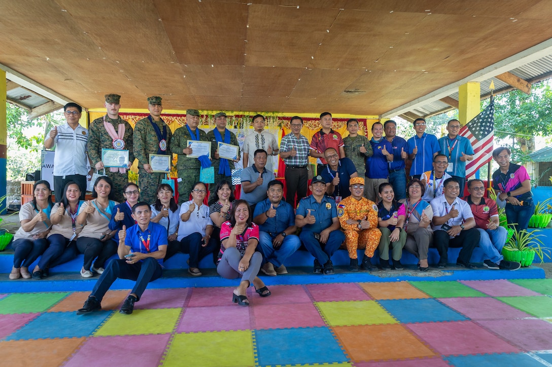 U.S. Marines pose for a group photo alongside soldiers with the Philippine Army and local leadership during a groundbreaking ceremony at Alannay Elementary School prior to the commencement of Exercise Balikatan 24 in Cagayan, Philippines, March 26, 2024. BK 24 is an annual exercise between the Armed Forces of the Philippines and U.S. military designed to strengthen bilateral interoperability, capabilities, trust, and cooperation built over decades of shared experiences. (U.S. Marine Corps photo by Cpl. Trent A. Henry)