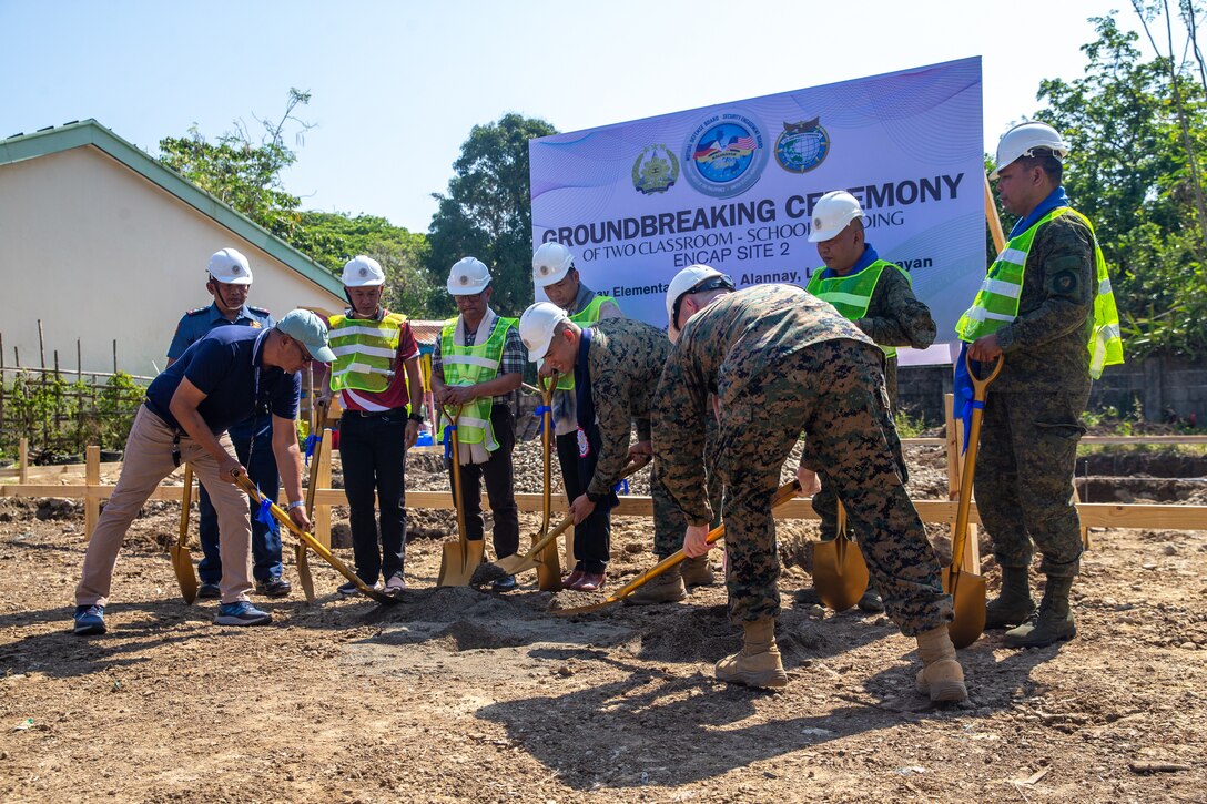 U.S. Marine Corps Lt. Col. Tyrone Barrion, center, a force engineer with I Marine Expeditionary Force and Capt. Daniel Asheim, right, a combat engineer officer with 9th Engineer Support Battalion, 3rd Marine Logistics Group, III Marine Expeditionary Force, bury a time capsule alongside soldiers with the Philippine Army and local leadership during a groundbreaking ceremony at Alannay Elementary School prior to the commencement of Exercise Balikatan 24 in Cagayan, Philippines, March 26, 2024. BK 24 is an annual exercise between the Armed Forces of the Philippines and U.S. military designed to strengthen bilateral interoperability, capabilities, trust, and cooperation built over decades of shared experiences. Barrion is a native of California and Asheim is a native of New York. (U.S. Marine Corps photo by Cpl. Trent A. Henry)