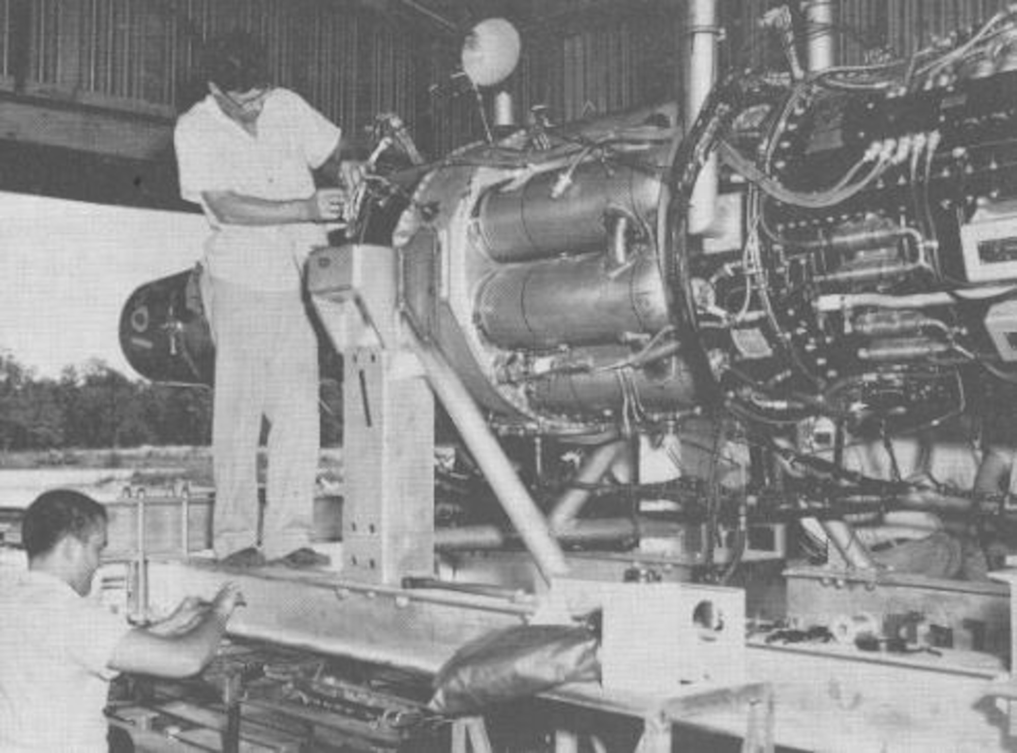 A J47 engine is prepared for open-air testing prior to being test fired on Aug. 27, 1953. This instrumentation test, which occurred near the then-under-construction Engine Test Facility at Arnold Air Force Base, Tenn., was conducted using a specially designed and constructed thrust stand. Pictured are I.F. Bailey, left, and L.C. Franks. The first turbojet engine test conducted at Arnold was initiated on May 3, 1954, in the T-1 test cell of the ETF on a J47 engine. (U.S. Air Force photo)